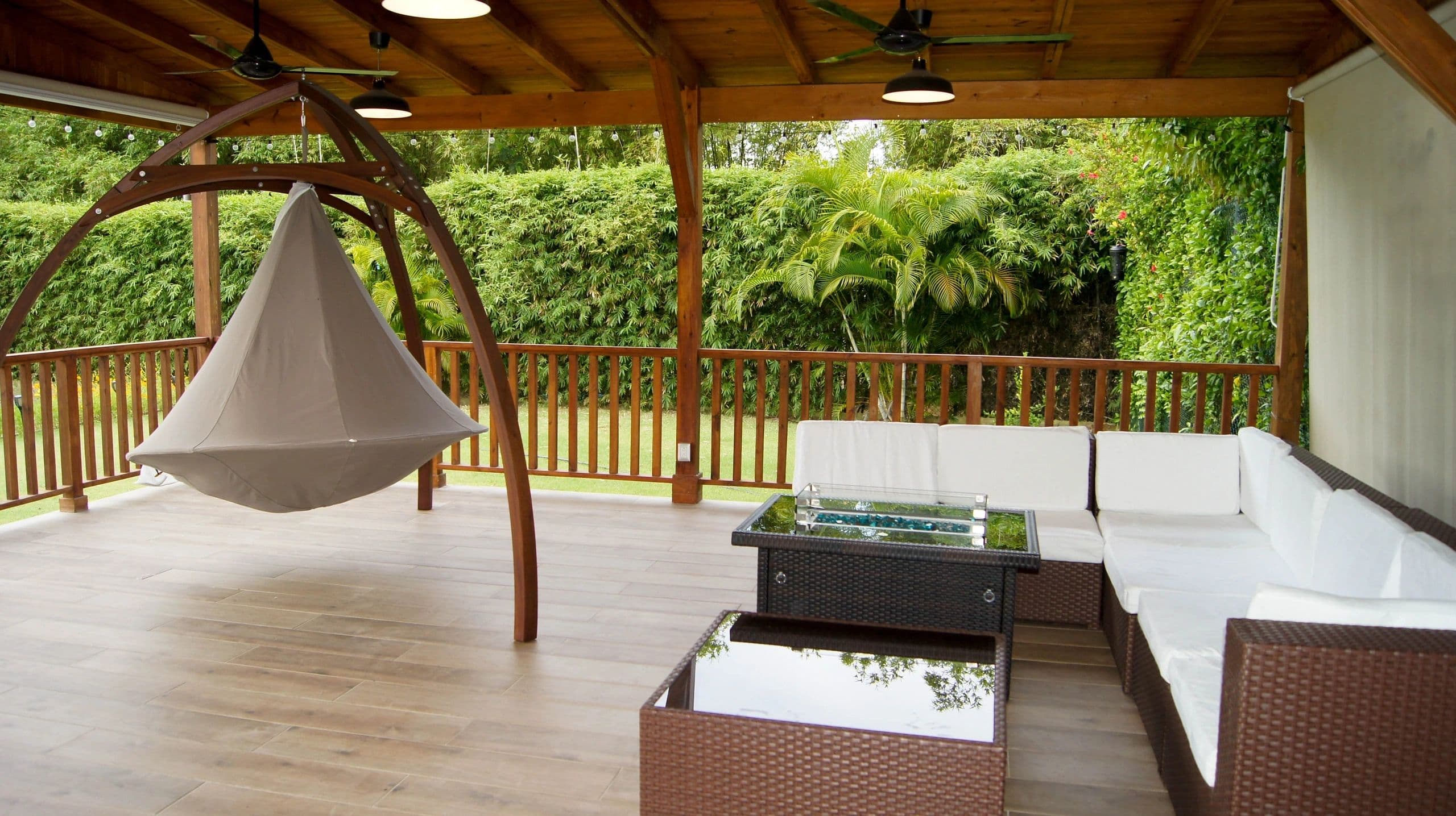 Covered gazebo with hanging chair and lounge seating